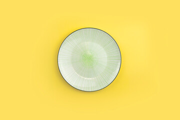 Mock up tableware composition with empty ceramic plate on yellow background. Minimalist concept. Trendy color and geometric design. Summertime table setting. Top view. Copyspace.