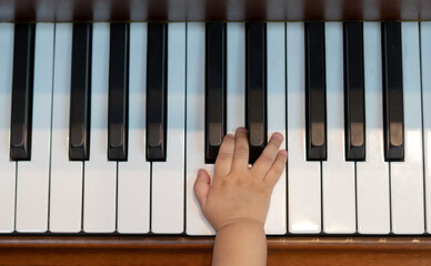 Baby Girl's Right Hand Playing with Piano Keys