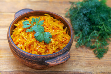 Braised cabbage, stewed with tomato sauce, served in a bowl on wooden table with green onion, parsley and dill