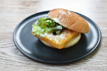 fried fish cheese hamburger with mayonnaise sauce and lettuce on plate