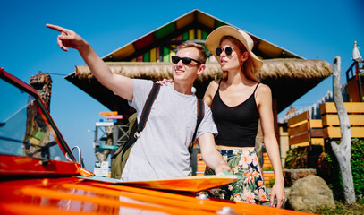 Obraz premium Young couple near car on beach