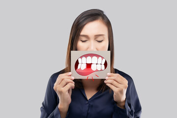 Asian woman in the dark blue shirt holding a brown paper with the broken tooth cartoon picture of...