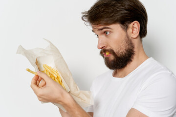 Side view of a surprised man with a box of french fries 