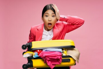 A beautiful girl in a jacket holds a suitcase