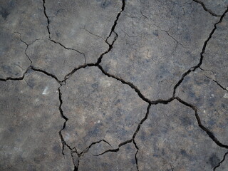 Surface of a grungy dry cracking parched earth for textural background.