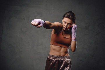 Fitness woman dressed in sportswear and bandages in studio