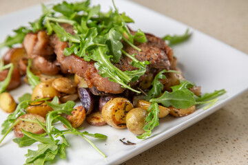 Rib eye steak with cut potatoes in green salad 
