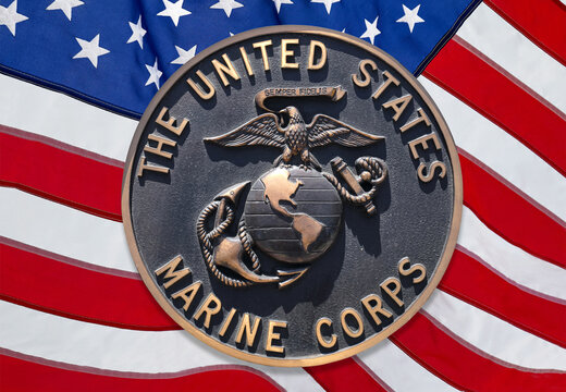 Los Angeles, California  USA - March 12 2019: U.S. Marine Corps logo or emblem, crest or plaque on American flag background