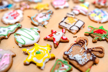 Fototapeta na wymiar Hand decorated baked gingerbreads of various shapes, arranged on baking paper.