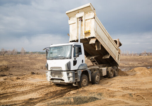dump truck performs earthwork at a construction site. Unloading the soil. Preparatory work on construction