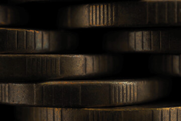 Wall from piles and edges of yellow coins close-up. Dark textured wallpaper or background for economic or financial theme. Brown noble color with patina. Ten Russian rubles. Reduced contrast. Macro