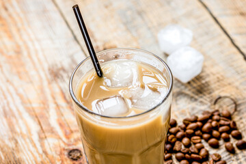 coffee ice cubes and beans with latte on wooden desk background