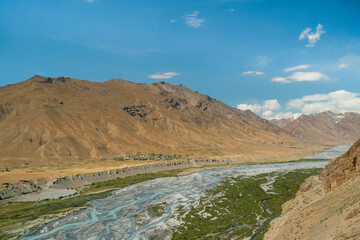 Spiti river and valley flanked by Himalayas under blue sky. Kaza, Himachal Pradesh, India.