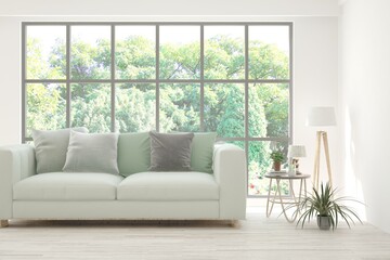 Fototapeta premium White living room with sofa and summer landscape in window. Scandinavian interior design. 3D illustration