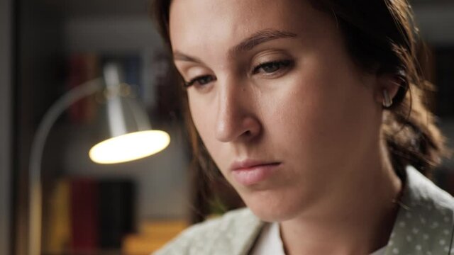 Headache. Close-up of woman face at night with pain in her head, she touches her forehead and temples with her fingers. Slow motion