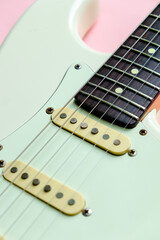 Fototapeta na wymiar Detail of White Electric Guitar on a pink background.