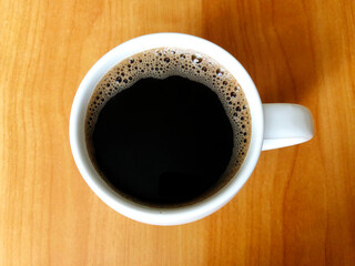cup of coffee on wood table, coffee cup on grunge wooden table top background, coffe cup closeup
