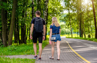 Obraz premium A guy and a girl walk along the path in the city Park 