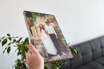 Canvas print stretched on stretcher bar with gallery wrap, hand holds wedding photography