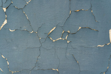 Cracked blue paint on a concrete wall