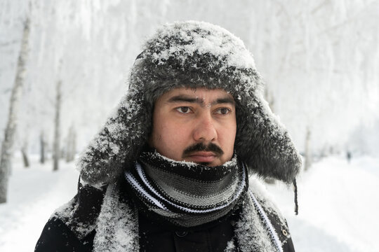 Formidable Russian man in a winter hat and scarf with a stern look