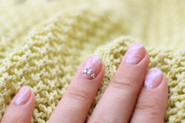 Nail polish. Artistic manicure. Modern style pink nail polish. Stylish pastel pink nails holding wool material sleeve blouse. The classic design of the bride's wedding nails