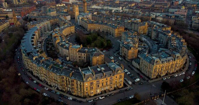 Aerial footage over Kelvingrove Park of the cityscape of Glasgow at sunset. Flying around the elegant buildings of Park Circus