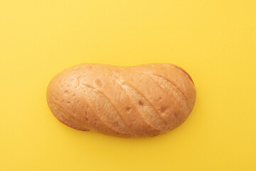Loaf, white bread, baton on yellow surface, top view, lay out, space for text