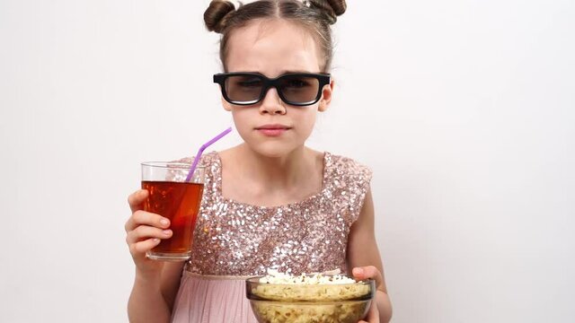 teen girl with glasses watch carefully 3D movies eats popcorn and drinks soda