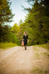 Obraz premium blonde girl in black dress with suitcase, selective focus