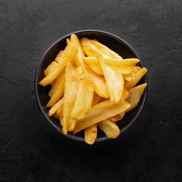 Potato Dips Fries In A Black Bowl On A Dark Textured Background, Top View.