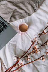 Pink mug with coffee stands on the bed Cotton blur Gray laptop