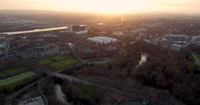 Flying in spring at sunset over the Kelvingrove park in Glasgow, Scotland towards the Gilbert Scott tower at Glasgow University.