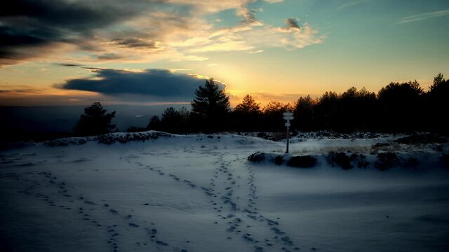 timelapse of sunset on Sicily mountains in winter clouds moving in the sky at the sun set on snow covered highlands of Etna Park 