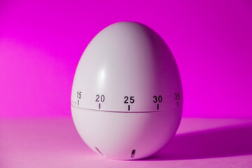 Classic retro white plastic egg kitchen clock, bright neon magenta background, a shadow from the right side