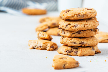 Heap of chocolate chip cookies on a gray table close-up. Sweet breakfast. Stack of traditional chip cookies with chocolate chunks.