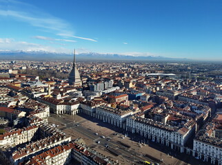 Aerial view of Turin city center, in Italy, in a sunny day, with Mole Antonelliana and Alps in the background.