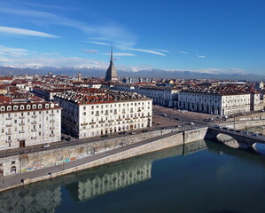 Aerial view of Turin city center, in Italy, in a sunny day, with Mole Antonelliana and Alps in the background.