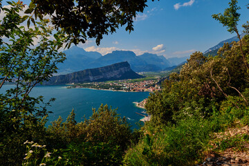 Fototapeta premium Panoramic view on Lake Garda from the Busatte-Tempesta trail near Nago-Torbole with the iron staircase, Torbole town surrounded by mountains in the summer time,Italy
