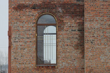 one large window on a brown wall of a building 