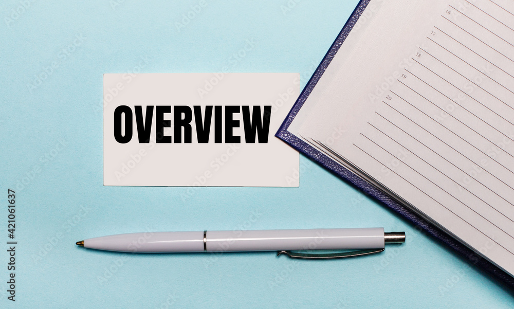 Poster on a light blue background, an open notebook, a white pen and a card with the text overview. view fr