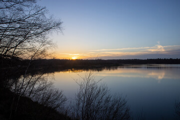 Dramatic and colorful sunset over a forest lake reflected in the water. Blakheide, Beerse, Belgium. High quality photo