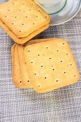A few crackers in a saucer on the table. Natural light.