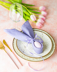 Easter table setting with pink tulip flowers and easter egg
