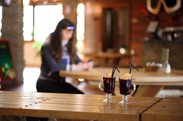 two glasses with hot tasty mulled wine on a wooden table in a cafe