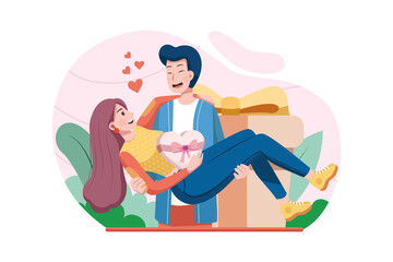 Young happy man holding woman in his arms with present in background