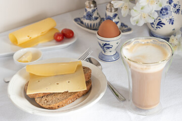 Breakfast table with bread, coffee, cheese, egg, jam