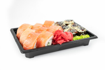 take away sushi in plastic containers, philadelphia rolls and unagi maki, soy sauce, pink ginger, wasabi, sushi delivery concept
