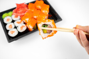 take away sushi rolls in plastic container, california, salmon maki roll, pink ginger, wasabi. sushi delivery concept