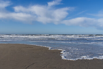waves on the beach with blue and cloudy sky